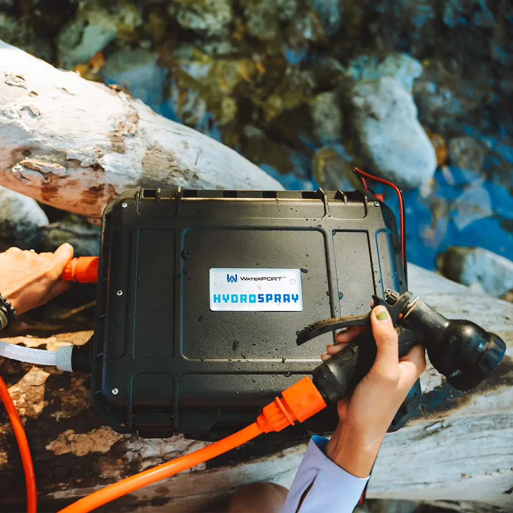 HydroSpray weatherproof case and spray nozzle with a person holding it by a body of water