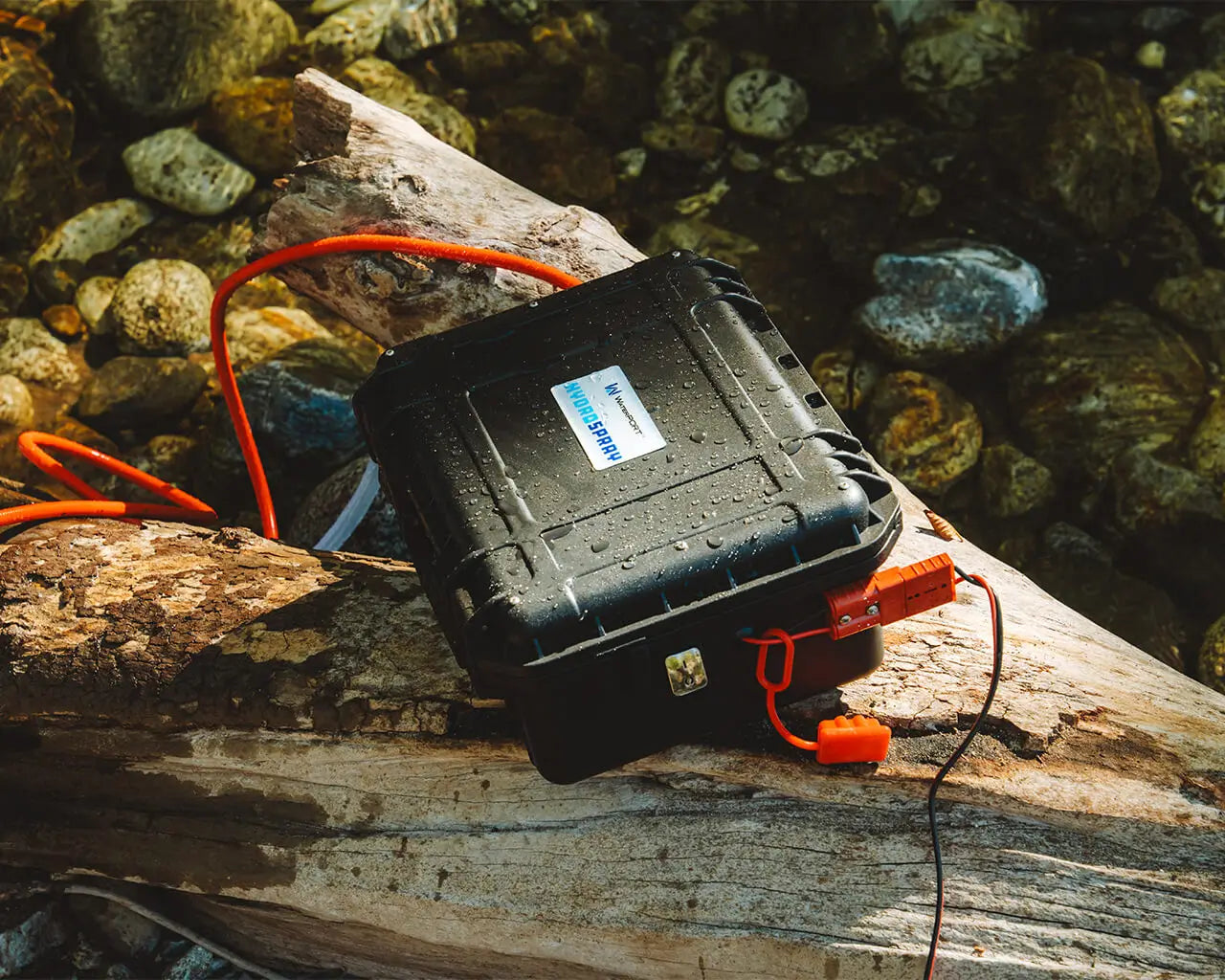 HydroSpray in a weatherproof case sitting on a log in a natural setting