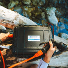 HydroSpray weatherproof case and spray nozzle with a person holding it by a body of water